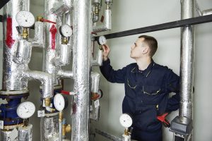 heating engineer repairman in boiler room